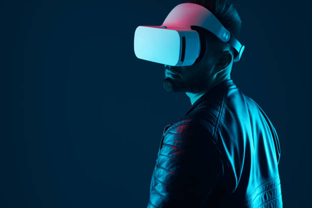 istock Serious man in VR headset in dark studio 1369437929