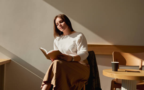 Young woman reading book in cafe