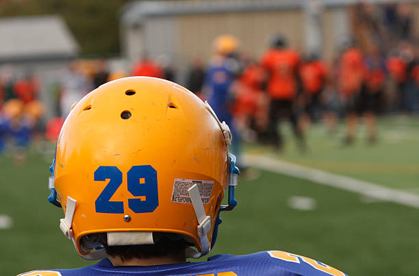 Teammate watching the field A football player watching his teammates on the field. safety american football player stock pictures, royalty-free photos & images