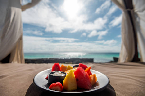 A plate with various fruits in luxury beach tents with canopies on the beach