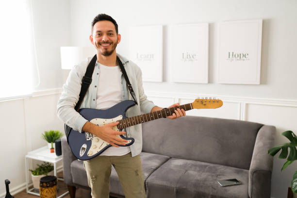 istock Attractive musician with a guitar on a strap 1369459301