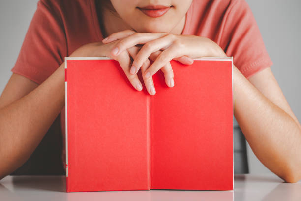 istock woman showing red blank page book. 1369461375