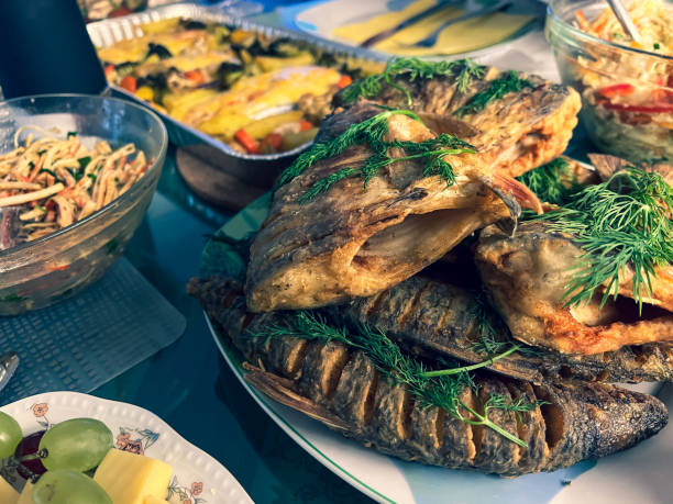 istock Delicious Christmas dinner with fish, vegetables, fruit and bread. 1369464421