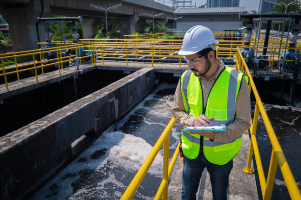 der ingenieur nimmt wasser aus dem abwasserbehandlungsteich, um die qualität des wassers zu überprüfen. nach dem durchlaufen des abwasserbehandlungsprozesses - umweltkatastrophe stock-fotos und bilder