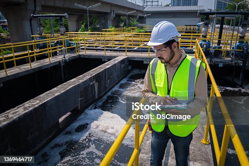 istock Engineer take water from  wastewater treatment pond to check the quality of the water. After going through the wastewater treatment process 1369464717