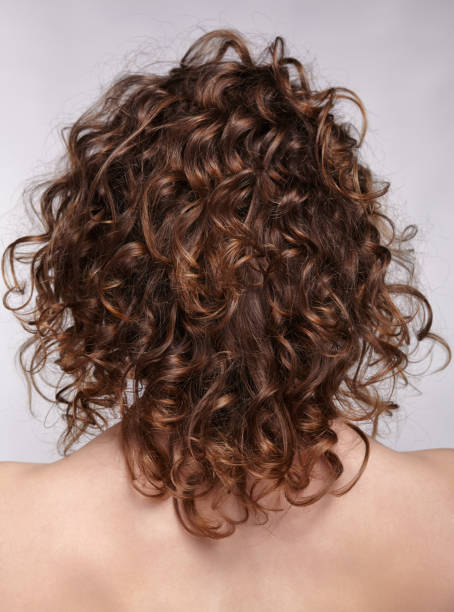 istock Woman from backside with curly hair 1369470294