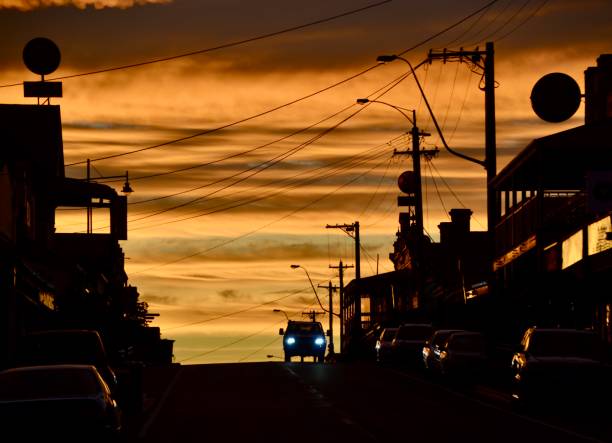Sunrise on the main street of the wine region town Rutherglen in Victoria with parked cars and pub signs in silhouette stock photo