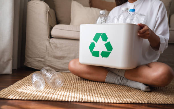 istock A woman collecting and separating recyclable garbage plastic bottles into a trash bin at home 1369473216