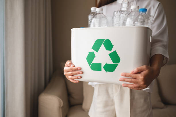 istock A woman collecting and separating recyclable garbage plastic bottles into a trash bin at home 1369473222