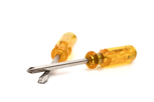 Two yellow handle screwdrivers are placed crossed over and separated from the white background.