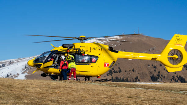 monte pora. bérgamo. itália. helicóptero de resgate sobre as montanhas para ajudar os caminhantes. helicóptero de primeiros socorros. helicóptero de resgate médico no chão. alpes italianos - rescue mountain horizontal three people - fotografias e filmes do acervo