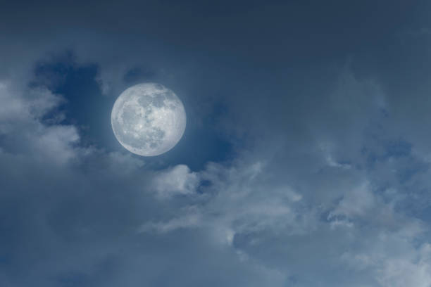 istock Amazing night sky with shining full moon and dramatic clouds 1369485976