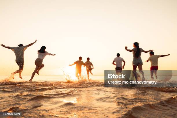 Big Group Of Friends Or Big Family Run At Sunset Beach Stock Photo - Download Image Now