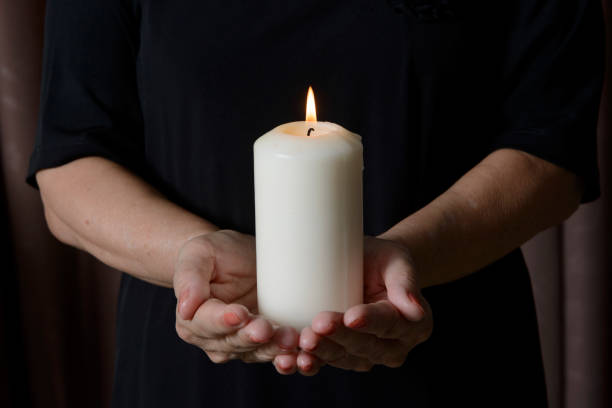 istock woman holding burning candle in darkness 1369486024
