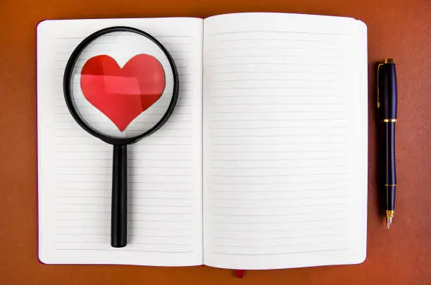 Blank Writing Pad with a Red Heart Shape in the Magnifying Glass