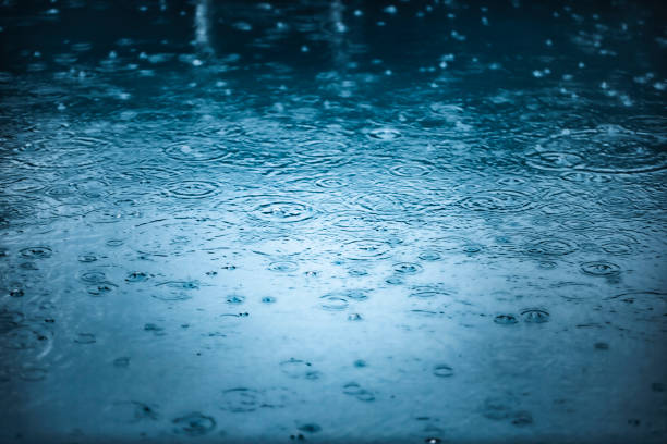 regenfall auf wasserhintergrund - überschwemmung stock-fotos und bilder