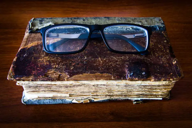 Vintage Book with a Glasses on the Table closeup