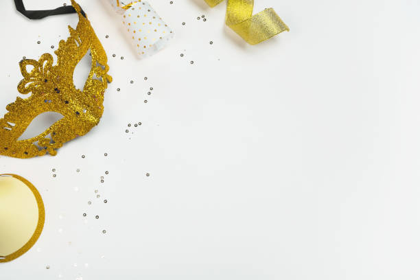 Carnival Mask with golden glitter and festive decorations on white background. Top view, flat lay, copy space