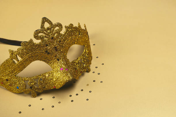 Carnival Mask with glitter on golden background. Copy space, closeup