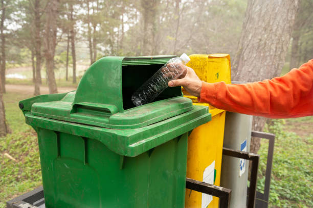 istock Hand of woman throwing plastic bottle into old trash can, 1369489642