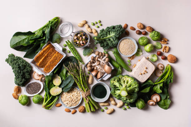 Variety of vegan, plant based protein food Variety of healthy vegan, plant based protein source and body building food. Tofu soy beans tempeh, green vegetables, nuts, seeds, quinoa oat meal and spirulina. View from above vegetarian food stock pictures, royalty-free photos & images