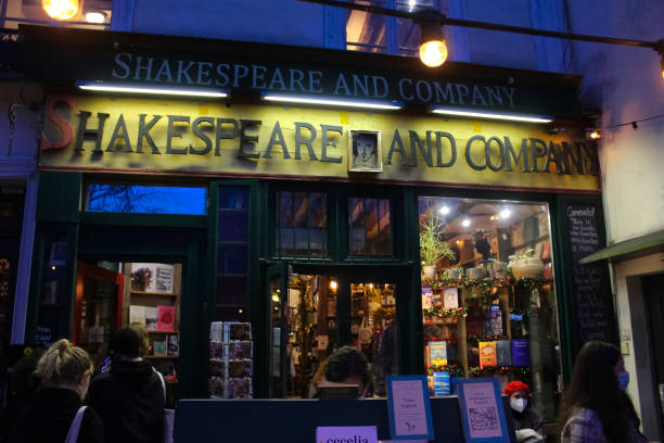 iluminado à noite shakespeare e biblioteca da companhia em paris. é uma biblioteca histórica localizada no quinto arrondissement de paris - shakespeare and company - fotografias e filmes do acervo