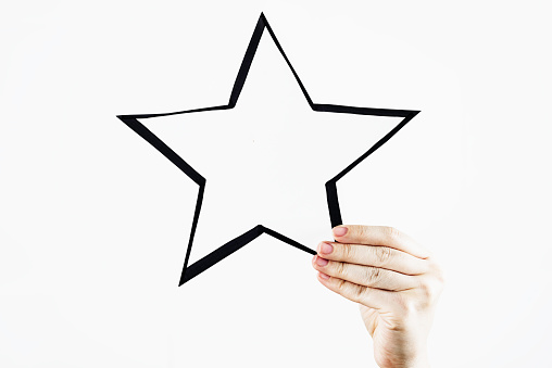 Hand is holding a star on white background