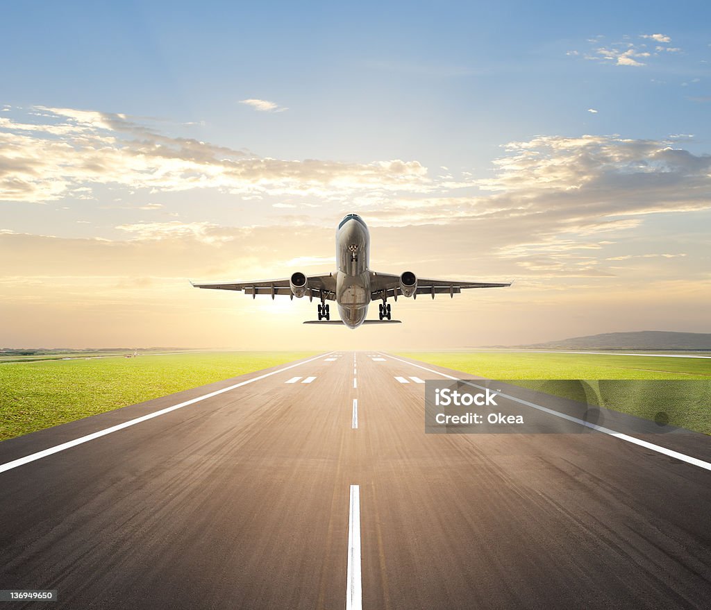 airplane landing airplane landing at airport during dusk hour Airplane Stock Photo