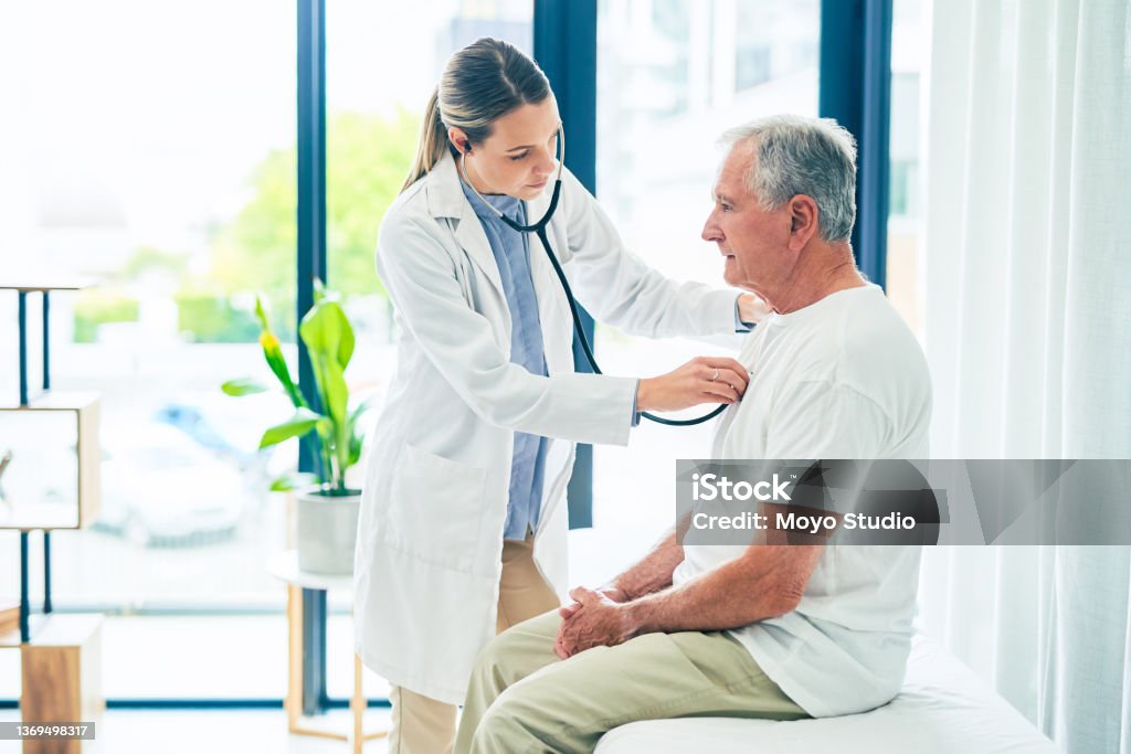 Shot of a female doctor giving a patient a chest exam Breathe deeply for me Doctor Stock Photo