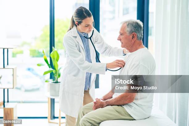 Shot Of A Female Doctor Giving A Patient A Chest Exam Stock Photo - Download Image Now