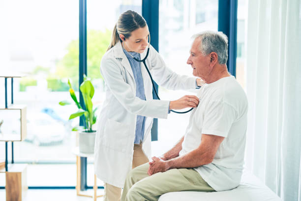 shot of a female doctor giving a patient a chest exam - respiratory system imagens e fotografias de stock