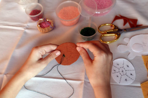 children's hands embroider a pattern on the shell of a turtle made of felt. - embroider imagens e fotografias de stock