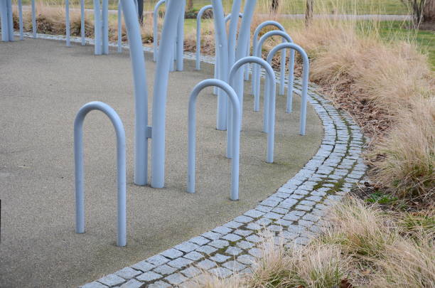 fahrradabstellraum mit glasdach mit gepunktetem aufdruck. konstruktion aus gebogenen grauen rohren in einen lichtbogen. gehärtetes verbundglas, das an metallgriffen in einem stadtpark befestigt ist. - x stand stock-fotos und bilder