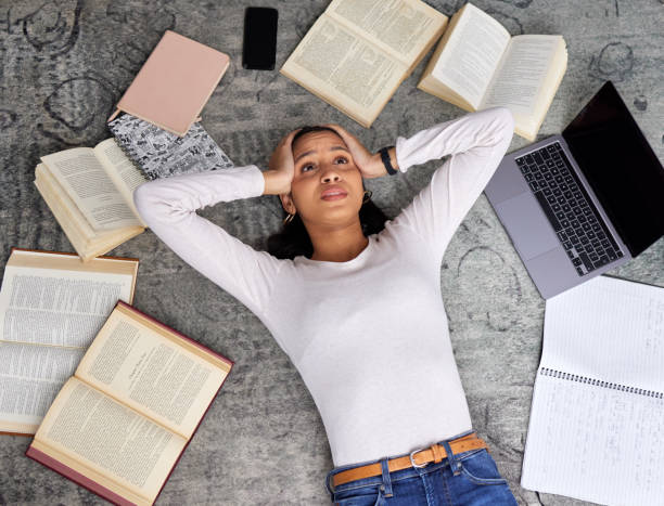 istock High angle shot of an attractive young female student looking stressed while studying in the library 1369503498