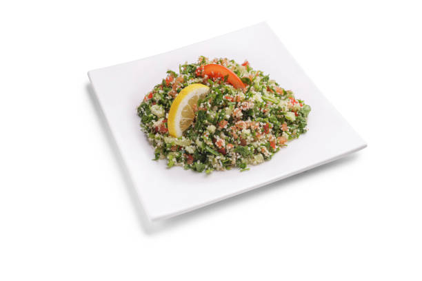 arabisches gericht taboulé auf einem quadratischen weißen teller - tabbouleh vegeterian food middle stock-fotos und bilder