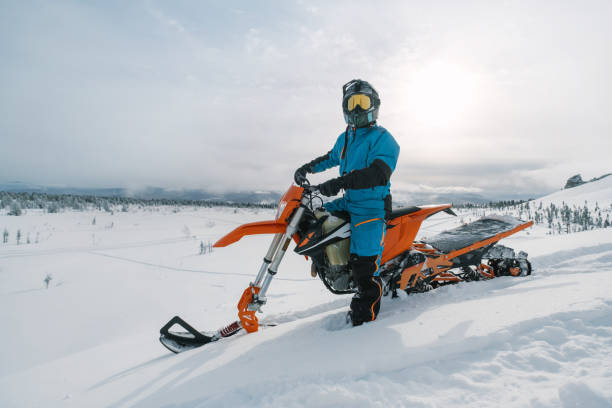 美しい雪の粉の山の谷でスノーバイクライダー。雪の水しぶきとトレイルでダートバイクを修正します。スノーモービルスポーツライディング、冬晴れの日 - snowmobiling snow winter mountain ストックフォトと画像