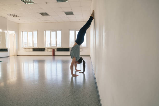 istock Woman doing yoga exercise near big mirror in empty yoga studio 1369506802