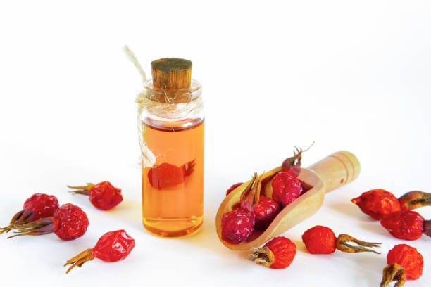 Rosehip tea on wooden background with red fruits The oil of the wild rose lying on a white surface, fruit of dogrose. wild rose hip stock pictures, royalty-free photos & images