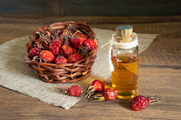 Rosehip tea on wooden background with red fruits Rosehip oil on wooden boards on canvas with dogrose fruit wild rose hip stock pictures, royalty-free photos & images