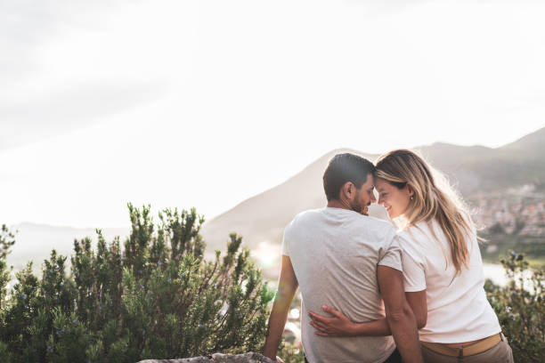 istock Young couple enjoying mountains at sunset 1369508303