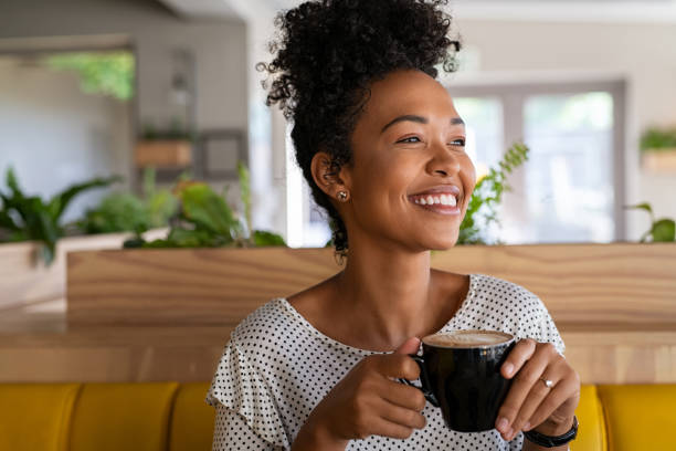 istock Beautiful black girl drinking coffee at cafe 1369508527