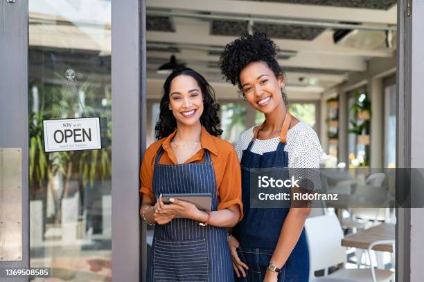 Two Successful Woman Waitress Standing At Cafe Entrance Door Stock Photo - Download Image Now