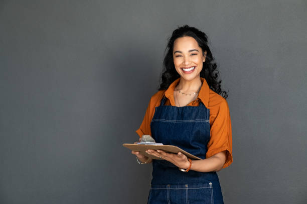 istock Happy smiling waitress holding clipboard to take orders 1369508843