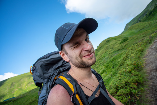 Funny smiling hiker in the mountains. Close-up portrait.