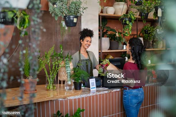 Happy Florist Selling Plants And Flower To Client Stock Photo - Download Image Now - Small Business, Customer, Owner