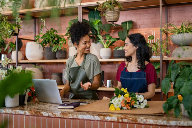 istock Two smiling women working at florist shop 1369509091