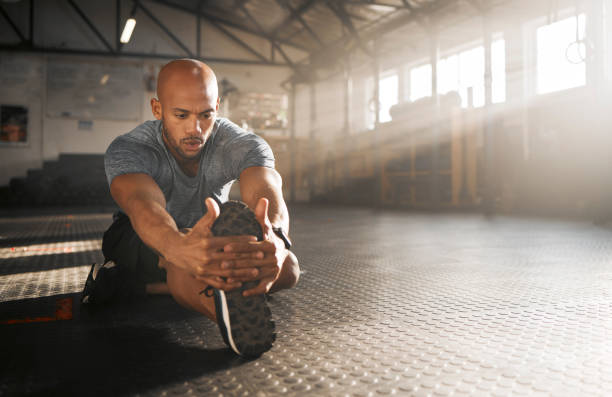 istock Shot of a young man stretching his legs before a workout 1369509360