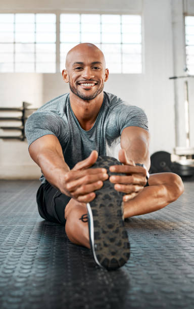 istock Shot of a young man stretching his legs before a workout 1369509375