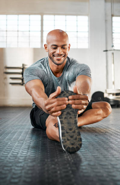 istock Shot of a young man stretching his legs before a workout 1369509379