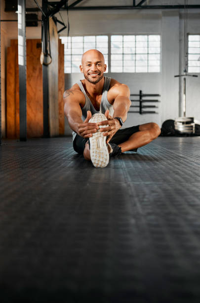 istock Shot of a young man stretching his legs before a workout 1369509380